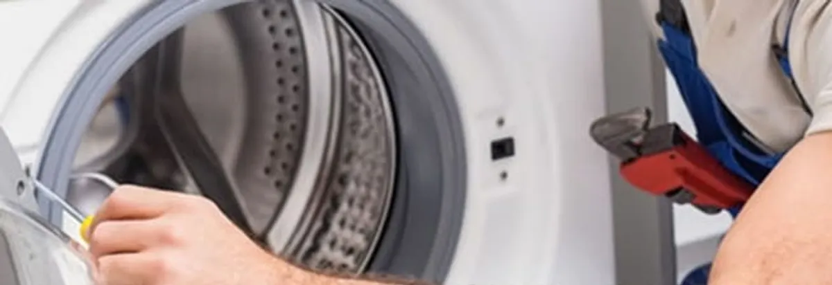 Appliance technician repairing a clothes dryer drum and internal parts in Milwaukee, WI