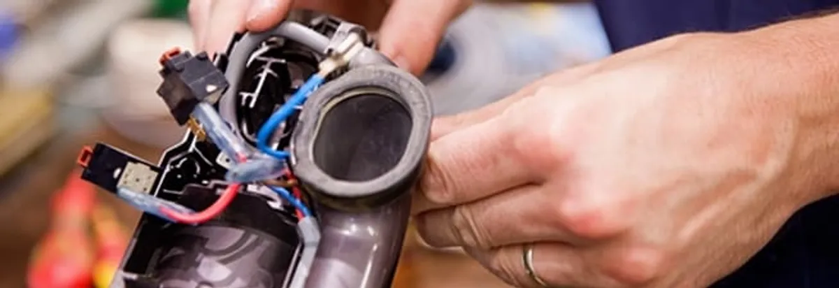 Vacuum repair technician reconnecting wiring and components in Milwaukee, WI