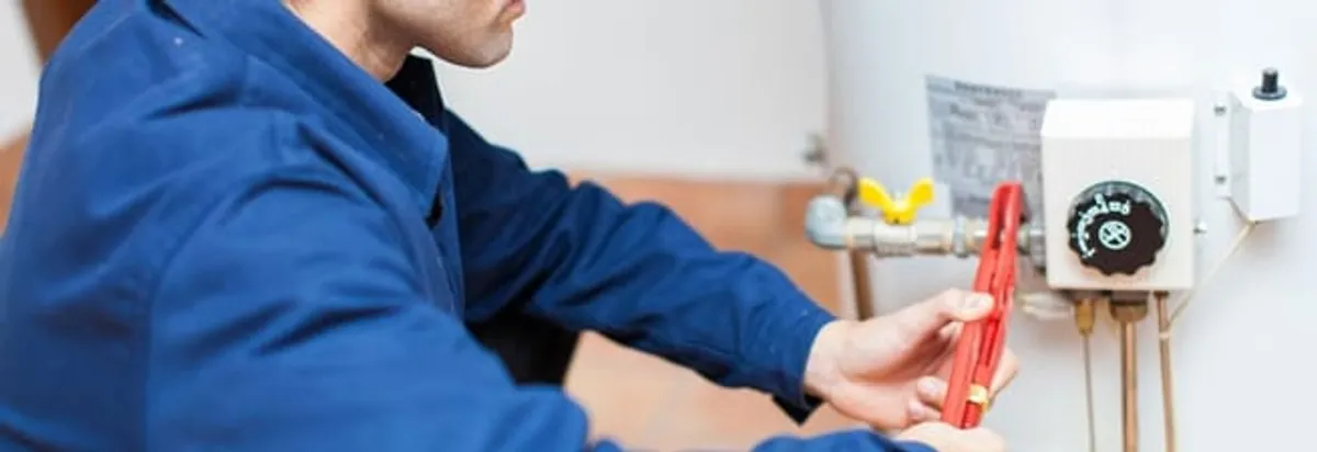 Water heater repair technician adjusting the temperature control and gas valve in Milwaukee, WI